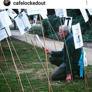 Man reading signs in park installation.