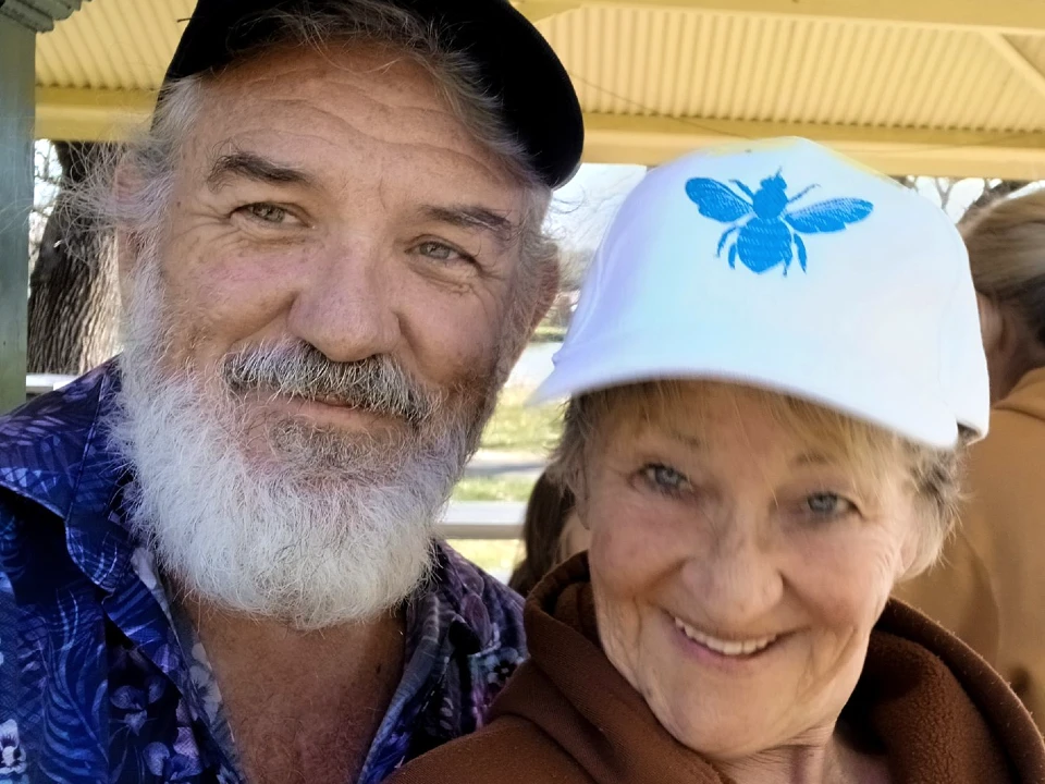 Smiling couple wearing hats outdoors.