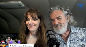 Two hosts smiling beside microphone during a livestream